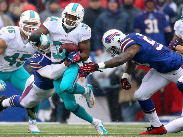 Marcus Thigpen of the Miami Dolphins is tackled as he returns a kick during NFL game action against the Buffalo Bills at Ralph Wilson Stadium on December 22, 2013