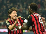 Milan's Sulley Muntari celebrates with teammate Riccardo Montolivo after scoring his team's second goal against Roma during their Serie A match on December 16, 2013