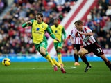 Johan Elmander of Norwich City is chased by Lee Cattermole of Sunderland during the Barclays Premier League match between Sunderland and Norwich City at Stadium of Light on December 21, 2013
