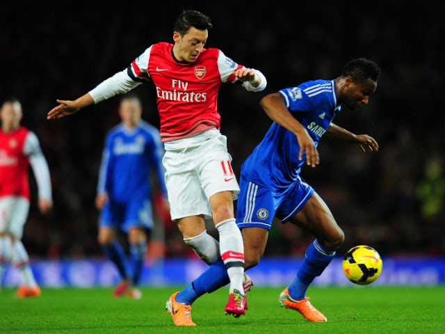 Mesut Ozil of Arsenal and John Obi Mikel of Chelsea compete for the ball during the Barclays Premier League match between Arsenal and Chelsea at Emirates Stadium on December 23, 2013