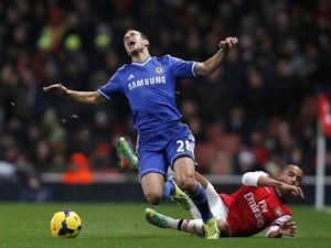 Chelsea's Spanish defender Cesar Azpilicueta is tackled by Arsenal's English striker Theo Walcott during the English Premier League football match between Arsenal and Chelsea at the Emirates Stadium in London on December 23, 2013