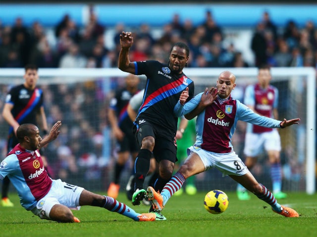 Cameron Jerome of Crystal Palace is tackled by Fabian Delph and Karim El Ahmadi of Aston Villa during the Barclays Premier League match between Aston Villa and Crystal Palace at Villa Park on December 26, 2013