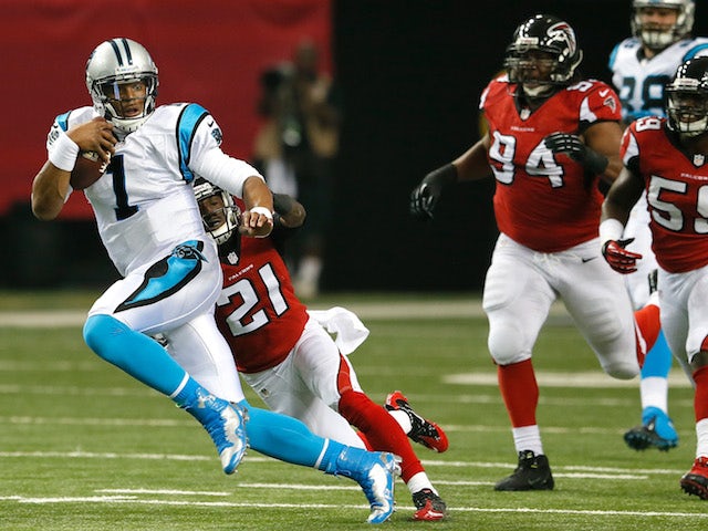 Cam Newton of the Carolina Panthers rushes away from Desmond Trufant of the Atlanta Falcons at Georgia Dome on December 29, 2013