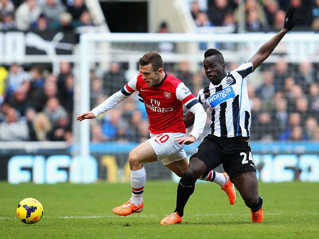 Newcastle's Cheick Tiote and Arsenal's Jack Wilshere battle for the ball during their Premier League match on December 29, 2013