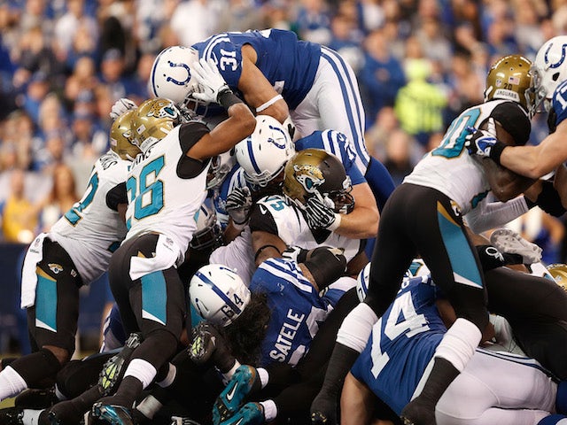 Donald Brown of the Indianapolis Colts dives over the pile of Jacksonville Jaguars defenders for a fist quarter touchdown at Lucas Oil Stadium on December 29, 2013