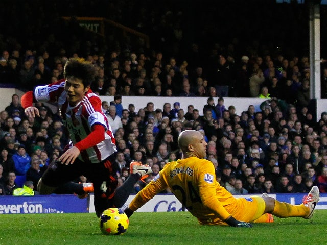 Tim Howard of Everton fouls Ki Sung-Yueng of Sunderland inside the penalty box during the Barclays Premier League match between Everton and Sunderland at Goodison Park on December 26, 2013