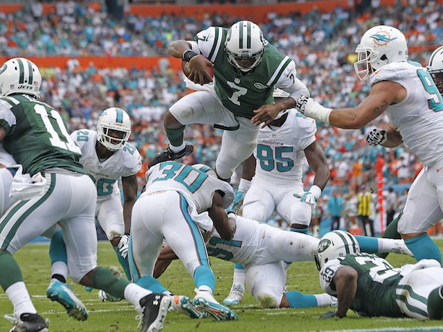 Geno Smith of the New York Jets dives for the end zone but is stopped short by the Miami Dolphins defense during second quarter action on December 29, 2013