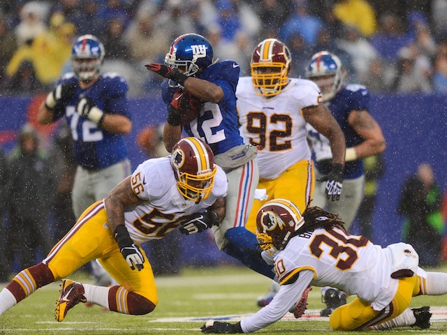 Wide receiver Jerrel Jernigan of the New York Giants avoids a tackle from inside linebacker Perry Riley and free safety E.J. Biggers of the Washington Redskins on December 29, 2013
