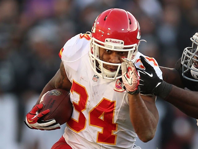 Knile Davis of the Kansas City Chiefs runs against Stacy McGee #92 of the Oakland Raiders at O.co Coliseum on December 15, 2013
