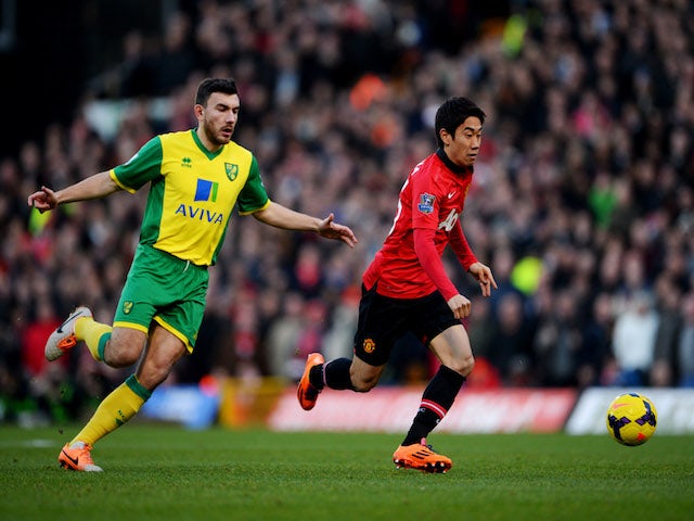 Shinji Kagawa of Manchester United is chased by Robert Snodgrass of Norwich City during the Barclays Premier League match on December 28, 2013
