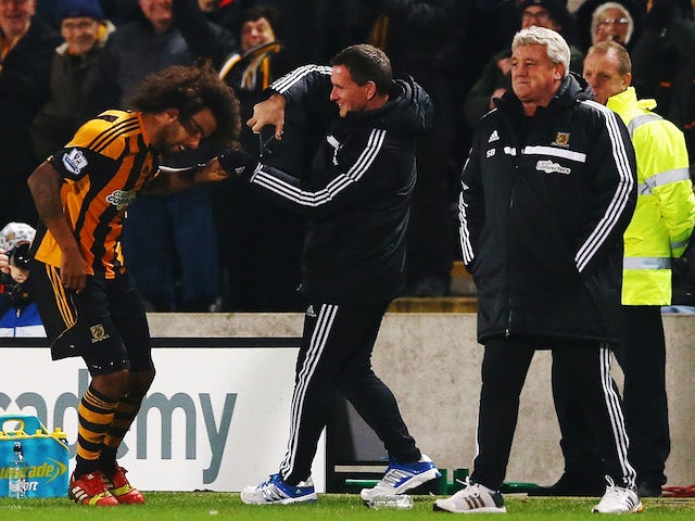 Tom Huddlestone of Hull City gets attention to his hair on the touchline after scoring during the Barclays Premier League match against Fulham on December 28, 2013