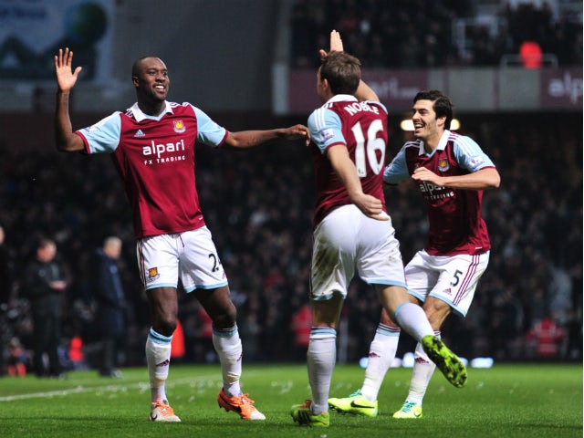 West Ham United's English striker Carlton Cole celebrates with teammates after scoring a goal during the English Premier League football match between West Ham United and Arsenal at the Boleyn Ground, Upton Park, in east London on December 26, 2013