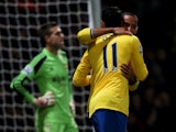 Theo Walcott of Arsenal celebrates with Mesut Ozil as he scores their first goal during the Barclays Premier League match between West Ham United and Arsenal at Boleyn Ground on December 26, 2013