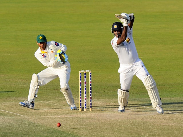 Sri Lankan batsman Angelo Mathews plays a shot as Pakistan wicketkeeper Younis Khan looks on during the fourth day of the first cricket Test match between Pakistan and Sri Lanka at the Sheikh Zayed Stadium in Abu Dhabi on January 3, 2014