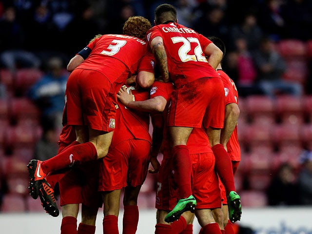 MK Dons' Ben Reeves is mobbed by teammates after scoring his team's second goal against Wigan during their FA Cup third round match on January 4, 2013
