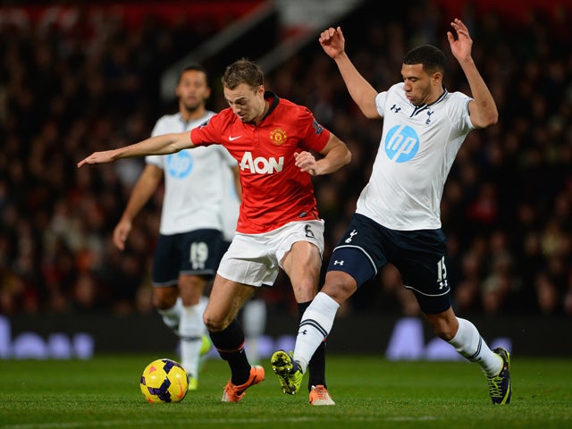 Jonny Evans of Manchester United competes with Etienne Capoue of Tottenham Hotspur during the Barclays Premier League match between Manchester United and Tottenham Hotspur at Old Trafford on January 1, 2014