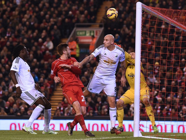 Swansea City's English midfielder Jonjo Shelvey deflects the ball into his own net from a corner for Liverpool's fourth goal during the English Premier League football match between Liverpool and Swansea City at Anfield in Liverpool, north west England, o