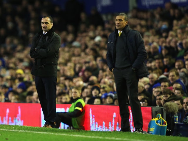 Roberto Martinez, manager of Everton looks on with Chris Hughton, manager of Norwich City during the Barclays Premier League match between Everton and Norwich City at Goodison Park on January 11, 2014