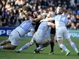 Toulouse's Jean-Marc Doussain is tackled by Saracens players during their Heineken Cup match on January 12, 2014