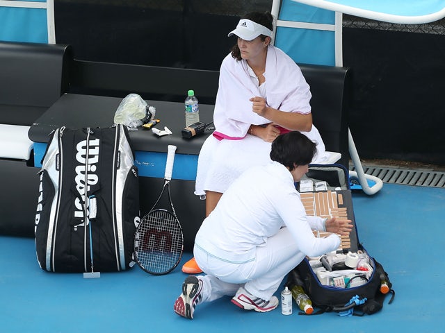 Laura Robson of Great Britain is treated by a trainer for a wrist injury in her first round match against Yanina Wickmayer of Belgium during day two of the Moorilla Hobart International at Domain Tennis Centre on January 6, 2014