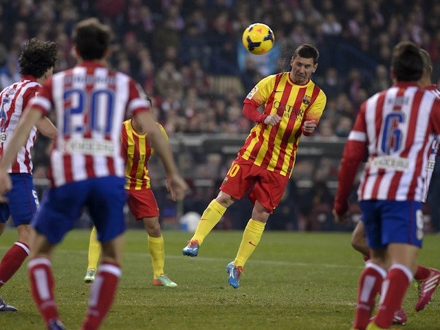 Barcelona's Argentinian forward Lionel Messi heads the ball during the Spanish league football match Club Atletico de Madrid vs FC Barcelona at the Vicente Calderon stadium in Madrid on January 11, 2014