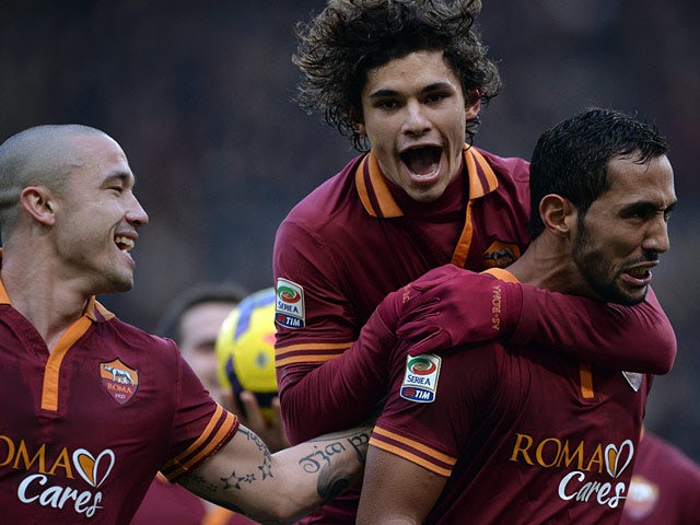 Roma's Mehdi Benatia celebrates with teammates after scoring his team's fourth goal against Genoa during their Serie A match on January 12, 2014