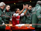 Theo Walcott of Arsenal makes a 2-0 gesture to the Tottenham fans as he is stretchered off the pitch during the Budweiser FA Cup third round match between Arsenal and Tottenham Hotspur at Emirates Stadium on January 4, 2014