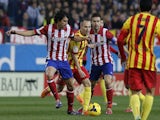 Atletico Madrid's Portuguese midfielder Tiago Mendes (L) vies with Barcelona's midfielder Andres Iniesta (C) during the Spanish league football match on January 11, 2014