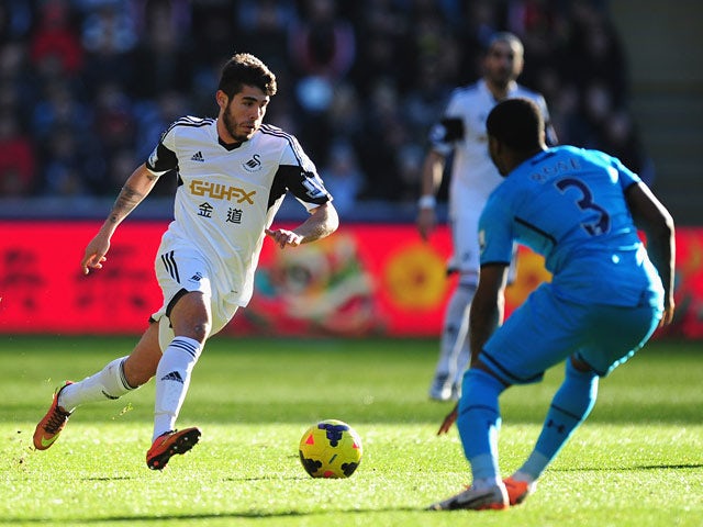 Swansea's Alejandro Pozuelo runs at Tottenham's Danny Rose during their Premier League match on January 19, 2014