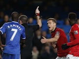 Referee Phil Dowdpoints off-field as Manchester United's Serbian defender Nemanja Vidic pleads after being shown a straight red card for a challenge on Chelsea's Belgian midfielder Eden Hazard during the English Premier League football match between Chels