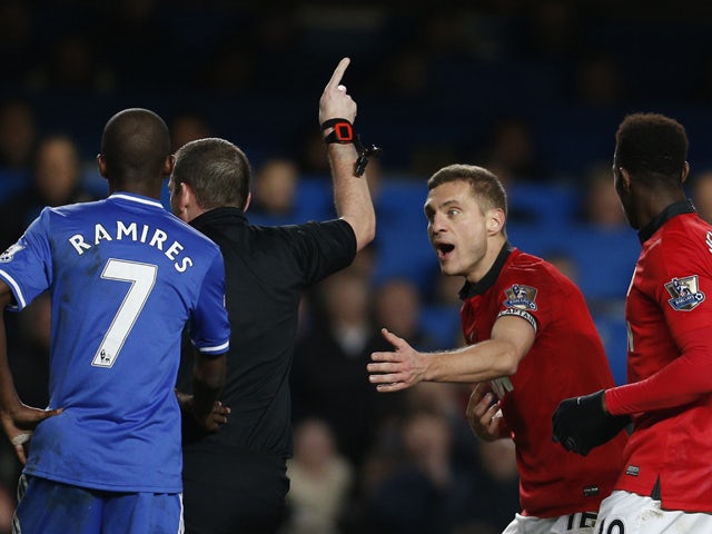Referee Phil Dowdpoints off-field as Manchester United's Serbian defender Nemanja Vidic pleads after being shown a straight red card for a challenge on Chelsea's Belgian midfielder Eden Hazard during the English Premier League football match between Chels