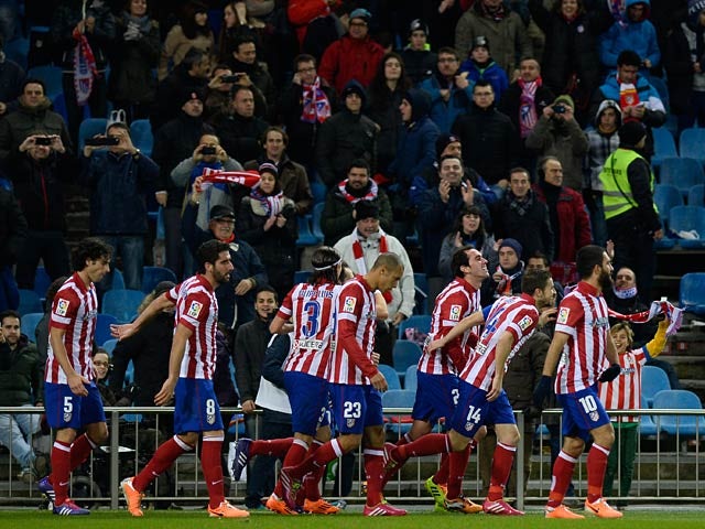 Atletico Madrid's Diego Godin celebrates with teammates after scoring the opening goal against Valencia during their Copa del Rey match on January 14, 2014