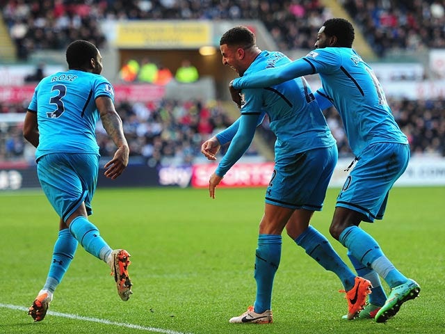 Tottenham's Kyle Walker celebrates his team's second goal with teammates Danny Rose and Emmanuel Adebayor against Swansea during their Premier League match on January 19, 2014