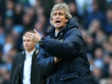 Manuel Pellegrini the Manchester City manager reacts as Ole Gunnar Solskjaer the Cardiff manager looks on during the Barclays Premier League match on January 18, 2014