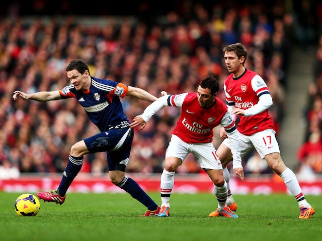 Sascha Riether of Fulham evades Santi Cazorla and Nacho Monreal of Arsenal during the Barclays Premier League match on January 18, 2014