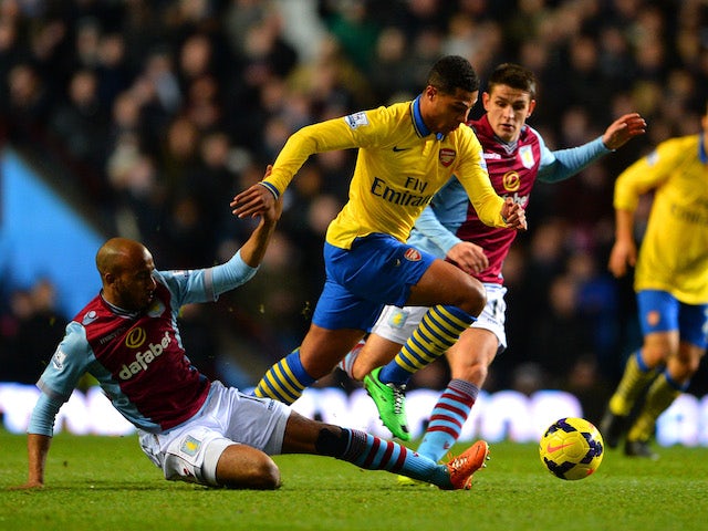 Fabian Delph of Aston Villa tackles Serge Gnabry of Arsenal during the Barclays Premier League match between Aston Villa and Arsenal at Villa Park on January 13, 2014