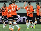 Lorient's French midfielder Yann Jouffre (R) celebrates with his teammates after scoring a goal during the French L1 football match between Lorient and Guingamp on January 18, 2014