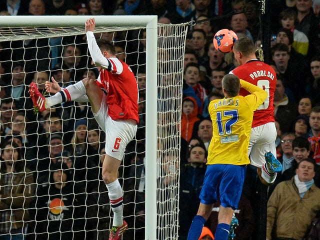 Arsenal's German striker Lukas Podolski scores his second goal during the English FA Cup fourth round match between Arsenal and Coventry City at the Emirates Stadium in London on January 24, 2014