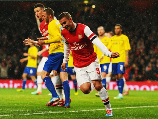 Lukas Podolski of Arsenal celebrates as he scores their second goal with a header during the FA Cup with Budweiser Fourth round match between Arsenal and Coventry City at Emirates Stadium on January 24, 2014 