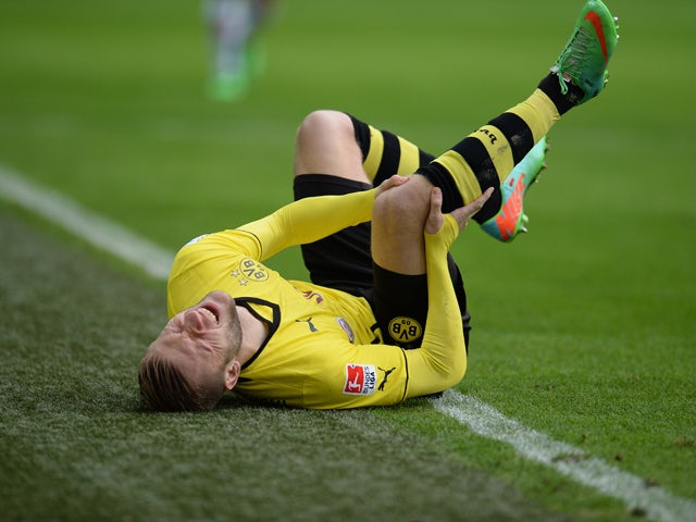 Dortmund's Polish midfielder Jakub Blaszczykowski lies on the pitch during the German first division Bundesliga football match Borussia Dortmund vs FC Augsburg in the German city of Dortmund on January 25, 2014