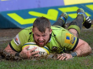 Gareth Denman of Saints slides through the mud as he scores a try during the LV Cup match between Newport Gwent Dragons and Northampton Saints at Rodney Parade on January 25, 2014