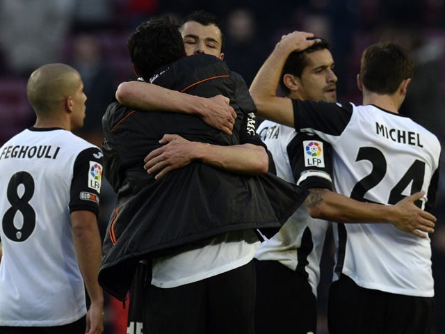 Valencia's football players celebrate their victory at the end of the Spanish league football match FC Barcelona vs Valencia CF at the Camp Nou stadium in Barcelona on February 1, 2014