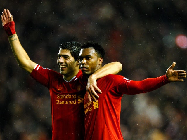 Daniel Sturridge of Liverpool is congratulated by teammate Luis Suarez after scoring his team's third goal during the Barclays Premier League match between Liverpool and Everton at Anfield on January 28, 2014