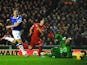 Luis Suarez of Liverpool scores his team's fourth goal past goalkeeper Tim Howard of Everton as Phil Jagielka of Everton closes in during the Barclays Premier League match between Liverpool and Everton at Anfield on January 28, 2014 