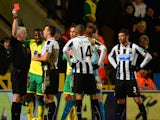 Referee Chris Foy shows Loic Remy of Newcastle United a red card during the Barclays Premier League match between Norwich City and Newcastle United at Carrow Road on January 28, 2014