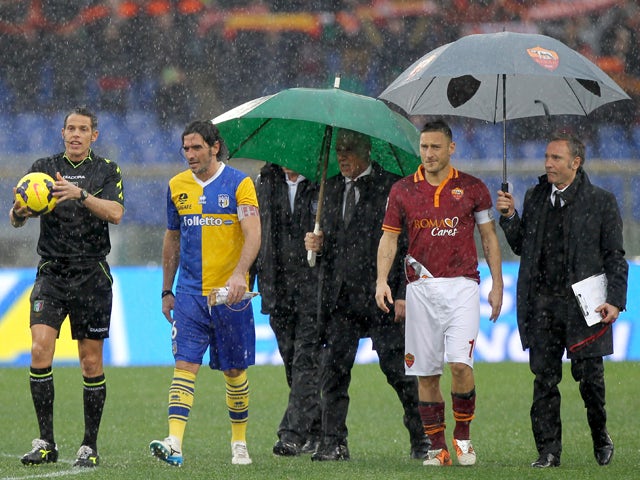 The referee Andrea De Marco with Alessandro Lucarelli of Parma FC and Francesco Totti of AS Roma check the field condition during the Serie A match between AS Roma and Parma FC at Stadio Olimpico on February 2, 2014
