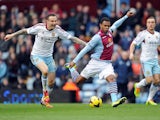 Leandro Bacuna of Aston Villa clears the ball as he comes under pressure from Matthew Taylor of West Ham United during the Barclays Premier League match between Aston Villa and West Ham United at Villa Park on February 8, 2014
