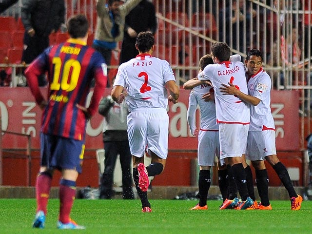 Sevilla's Bryan Rabello is congratulated by teammates after scoring the opening goal against Barcelona during their La Liga match on February 9, 2014