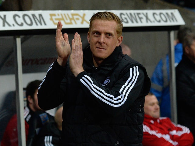 Swansea's new head coach Garry Monk greets fans ahead of the match against Cardiff during their Premier League match on February 8, 2014