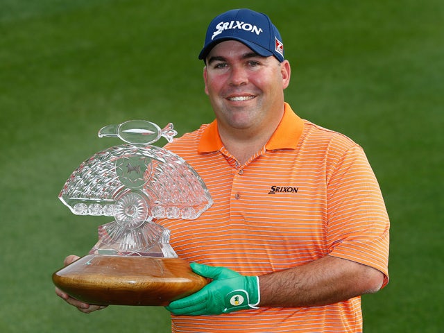 Kevin Stadler poses with the championship trophy after winning the Waste Management Phoenix Open at TPC Scottsdale on February 2, 2014